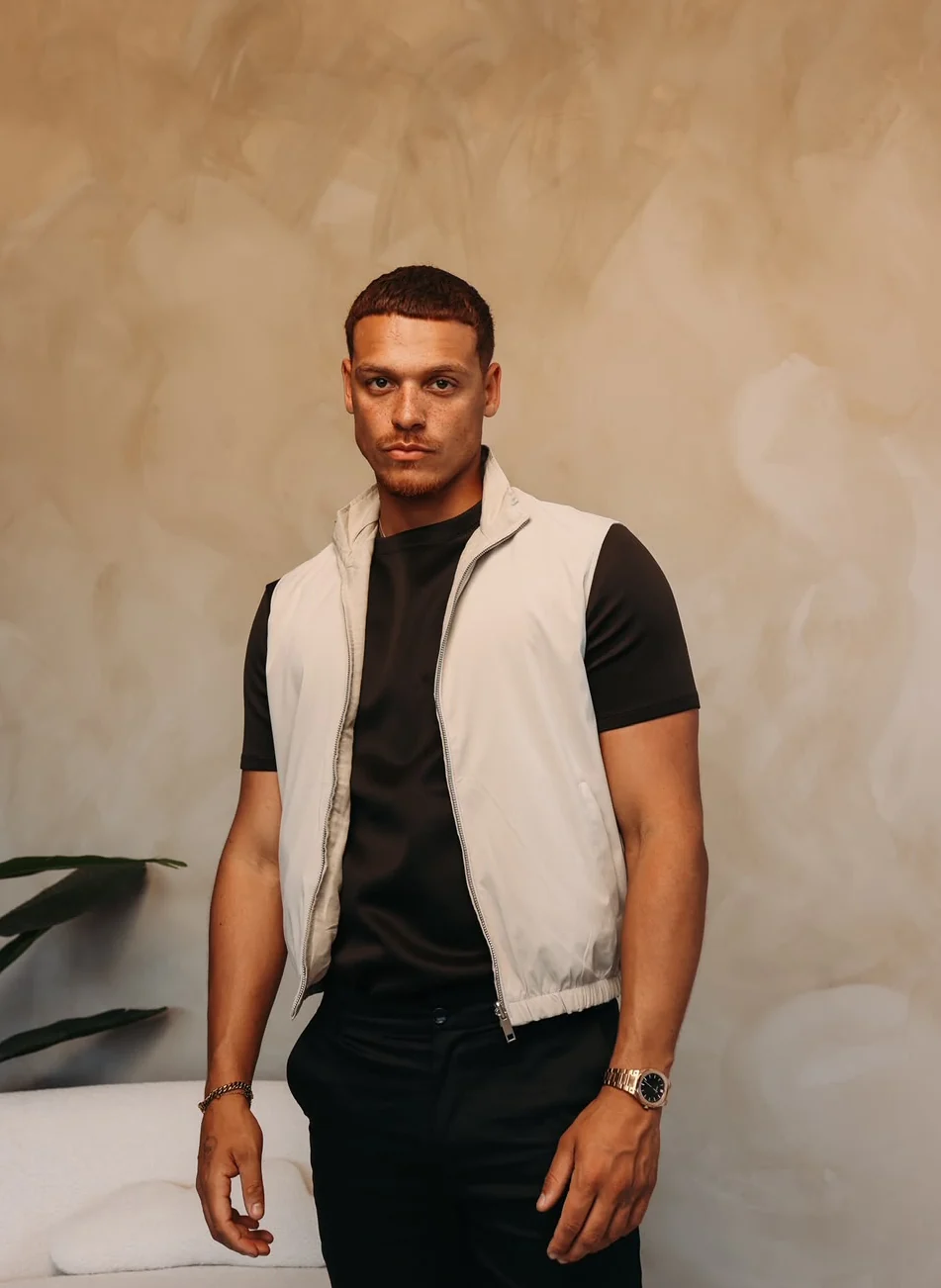 Beige bodywarmer over een zwart shirt